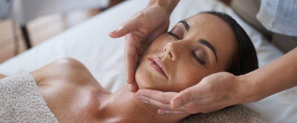 Eine Frau, die im Gesicht massiert wird